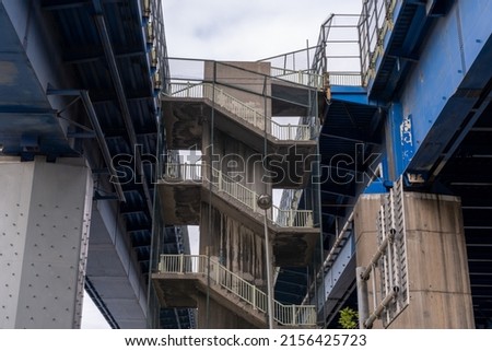 Grey zigzag stairs between two bridges, architecture and structure concept, front view, old stair, emergency exit stairs