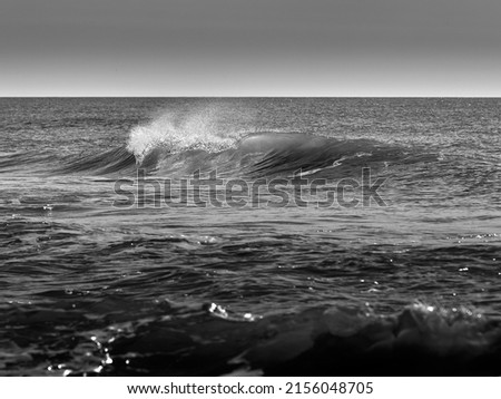 A greyscale shot of the waves of the sea