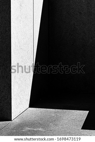 A greyscale vertical picture of a building corner with shadows - an abstract background