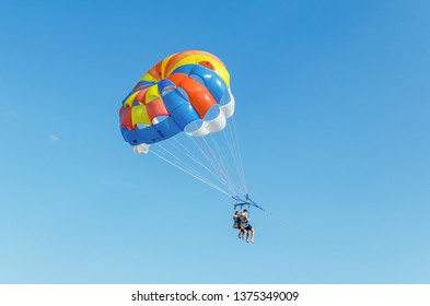 Gribovka, Ukraine, August 05 2018: Parasailing is an extreme sport, people fly by parachute against the blue sky.