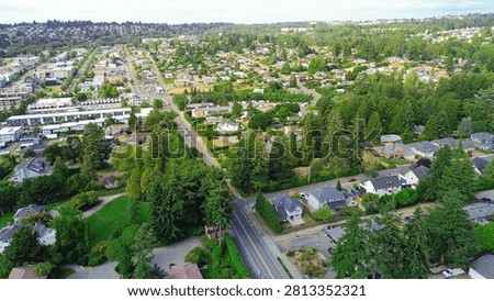 Grid development patterns connect commercial zones to residential sectors throughout municipality. Transit thoroughfares navigate around mature woodland foliage characteristic of Des Moines, WA. USA