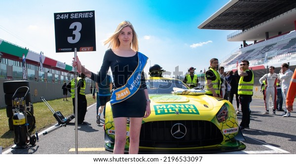 Grid girl on motor\
sport starting grid beautiful woman and car. Mugello, Italy, march\
26 2022. 24 Hours series