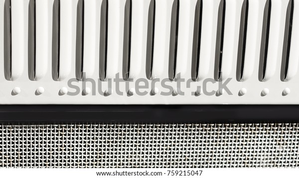 Grid grille in the hood of vintage car close\
up. Black and white color\
background