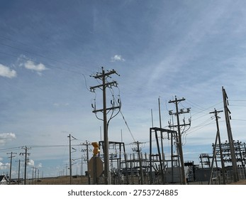 Grid infrastructure and transmission framework structures rising across open prairie sky in rural Alberta energy corridor.