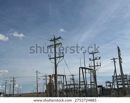 Grid infrastructure and transmission framework structures rising across open prairie sky in rural Alberta energy corridor.