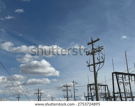 Grid infrastructure and transmission framework structures rising across open prairie sky in rural Alberta energy corridor.