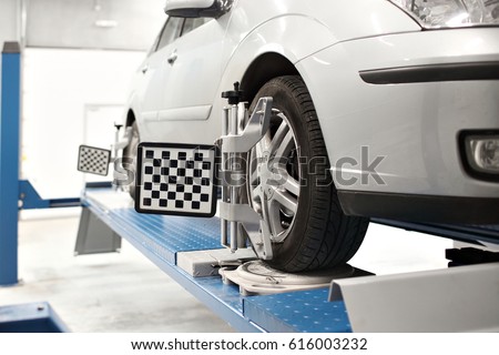 Grid sensor sets mechanic on auto. Car stand with sensors wheels for alignment camber check in workshop of Service station.
