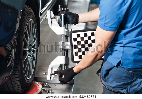 Grid sensor sets mechanic on auto. Car  stand\
with sensors wheels for alignment camber check in workshop of\
Service station.
