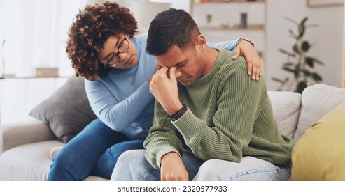 Grief, loss with mental health and sad, stress and people in relationship in crisis. Couple, depression and woman comfort man with empathy, support and love while sitting in living room at home.