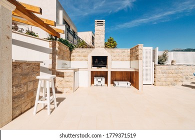 Grill area in the villa by the sea. A large courtyard with a stone grill and an open white stone kitchen.