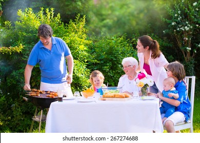 Grill Barbecue Backyard Party. Happy Big Family - Young Mother And Father With Kids,  Son, Toddler Daughter And Baby, BBQ Lunch With Grandmother Eating Grilled Meat In The Garden With Salad And Bread.