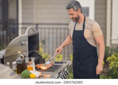 Grill and barbecue cook. Chef with BBQ cooking tools. Barbecue and grill. Picnic barbecue party. Chief cook with utensils for barbecue grill. Barbeque on holiday picnic. Man grilling a steak on BBQ. - Shutterstock ID 2301762303