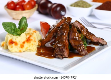 Grillfleisch-Tenderloin mit Grillsoße und Kartoffelpüree auf weißem Teller