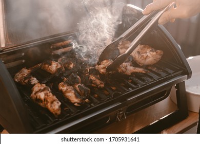 Grill Season Outdoor In Park Or Balcony. Spring Summer Grilling. Balcony Gas Grill. Barbeque Fourth Of July Weekend. Chicken Wings On Grill. Flame And Smoke Over Grill. BBQ Quarantine On Balcony.