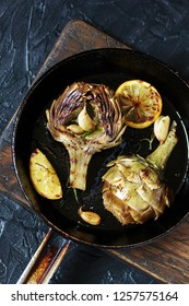 grilled artichoke with lemon in a pan.  Flatlay.  copy space. top view