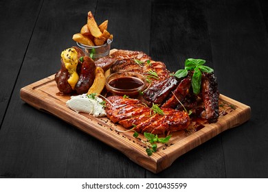 Grilled assorted meat platter with potato wedges and sauces