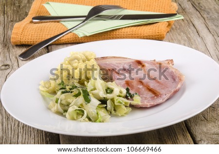 grilled bacon with cabbage and mashed potato on a plate