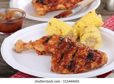 Grilled Barbecue Chicken And Corn On The Cob On A Paper Plate