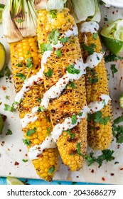 Grilled BBQ Corn Cob With Herbs, Lime And Garlic Sauce. Mexican Street Food Or Summer Garden Party Snack.