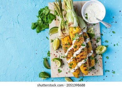 Grilled BBQ Corn Cob With Herbs, Lime And Garlic Sauce. Mexican Street Food Or Summer Garden Party Snack.