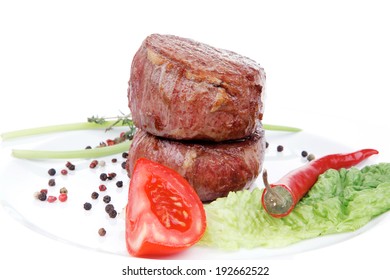 gegrillte Rinderfilet-Medaillons auf Nudeln mit rotem scharfen Chilischoten und Salatblatt auf weißem Hintergrund einzeln auf weißem Hintergrund