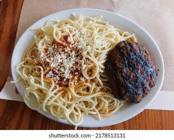 A Grilled Beef Patty Served With Spaghetti