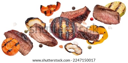 Grilled beef slices and chopped vegetables isolated on white background