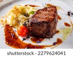 Grilled beef steak filet mignon with potato and sauce in plate