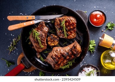 Grilled beef steak with herb and spices. Portion of fried meat cuts with rosemary, garlic, olive oil and ketchup sauce - Shutterstock ID 2395424509
