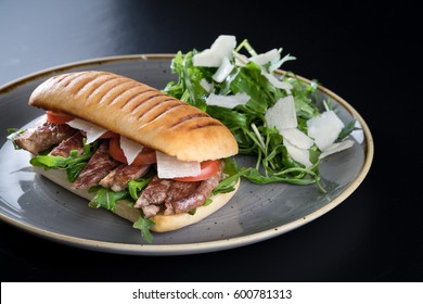 Grilled Beef Steak Medium Sliced Ciabatta Sandwich Salad Tomato Parmesan Cheese Rocket Green Rustic Plate 