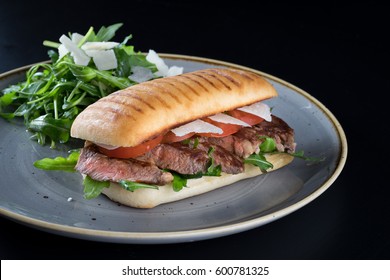 Grilled Beef Steak Medium Sliced Ciabatta Sandwich Salad Tomato Parmesan Cheese Rocket Green Rustic Plate 