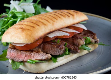 Grilled Beef Steak Medium Sliced Ciabatta Sandwich Salad Tomato Parmesan Cheese Rocket Green Rustic Plate 