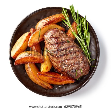 grilled beef steak and potatoes on plate isolated on white background, top view