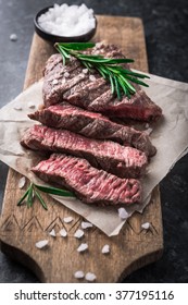 Grilled beef steak with rosemary and salt on cutting board - Shutterstock ID 377195116
