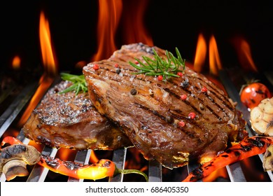 Grilled beef steak with vegetable on the flaming grill