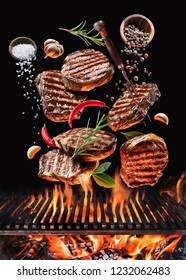 Grilled Beef Steaks With Vegetables And Spices Fly Over The Blazing Grill Barbecue Fire. Concept Of Flying Food.