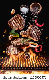 Grilled Beef Steaks With Vegetables And Spices Fly Over The Blazing Grill Barbecue Fire. Concept Of Flying Food.