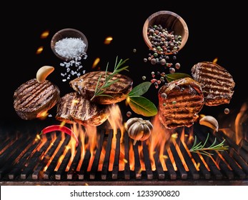 Grilled Beef Steaks With Vegetables And Spices Fly Over The Blazing Grill Barbecue Fire. Concept Of Flying Food.