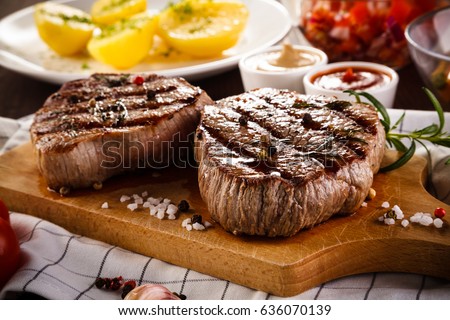 Grilled beefsteaks on cutting board - dinner preparation 