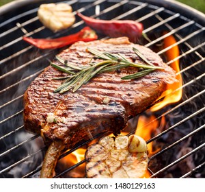 Grilled Bone-in Pork Chop, Pork Steak, Tomahawk In Spicy Marinade On A Flaming Grill,  Close-up. Barbecue, Bbq Meat