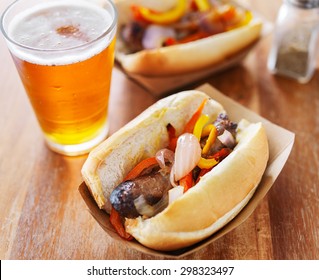 Grilled Bratwurst Covered In Onions And Peppers With Beer