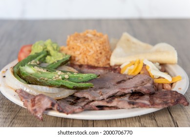 Grilled Carne Asada Steak Meat, Hot And Served With Rice And Cooked Jalapeno Peppers.