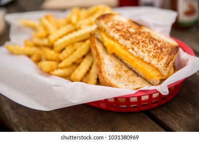 Grilled Cheese Sandwich With French Fries In Basket Cut In Half Melted Cheddar