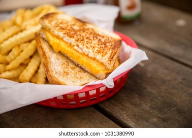 Grilled Cheese Sandwich With French Fries In Basket Cut In Half Melted Cheddar