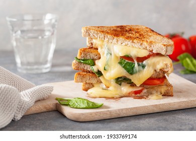 Grilled Cheese Spinach And Tomato Sandwich On Concrete Background