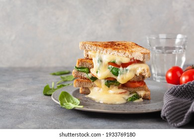 Grilled Cheese Spinach And Tomato Sandwich On Concrete Background