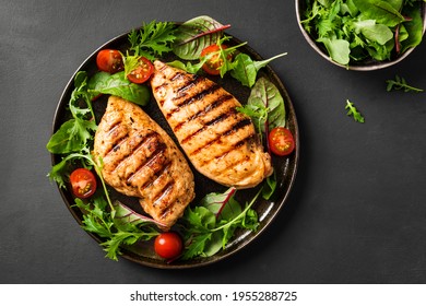 Grilled chicken breast, fillet, steak and fresh vegetable salad, top view, copy space. Healthy keto, ketogenic lunch menu with chicken meat and organic veggies and greens.
