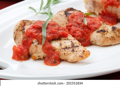 Grilled Chicken Breast With Fresh Tomato Tarragon Sauce, Spinach - Citrus Salad, And Orange Juice. 