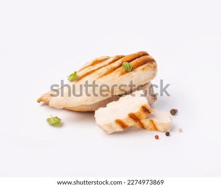 Grilled chicken breast isolated on white background. Grilled chicken slices with pepper mix peas and fresh basil leaves.