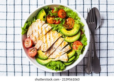 Grilled chicken breast salad with avocado and cherry tomatoes in white bowl, top view. Healthy diet food concept. - Shutterstock ID 2139561063
